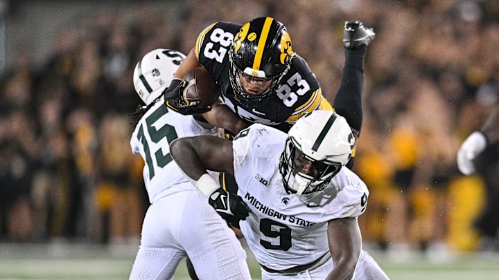 Sep 30, 2023; Iowa City, Iowa, USA; Michigan State Spartans defensive lineman Zion Young (9) and defensive back Angelo Grose (15) tackle Iowa Hawkeyes tight end Erick All (83) during the fourth quarter at Kinnick Stadium. Mandatory Credit: Jeffrey Becker-Imagn Images