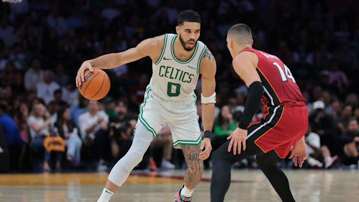 Mar 14, 2025; Miami, Florida, USA; Boston Celtics forward Jayson Tatum (0) dribbles the basketball as Miami Heat guard Tyler Herro (14) defends during the fourth quarter at Kaseya Center. Mandatory Credit: Sam Navarro-Imagn Images