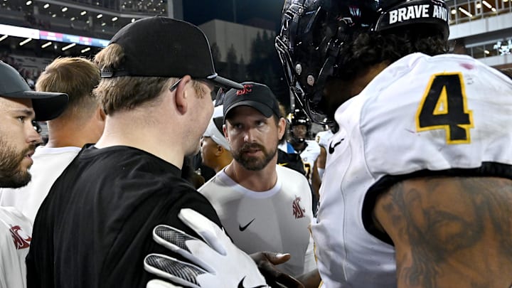 Aug 30, 2025; Pullman, Washington, USA; Washington State Cougars head coach Jimmy Rogers, center, talks with a member of the Idaho Vandals staff after a game at Gesa Field at Martin Stadium. Washington State Cougars won 13-10. Mandatory Credit: James Snook-Imagn Images