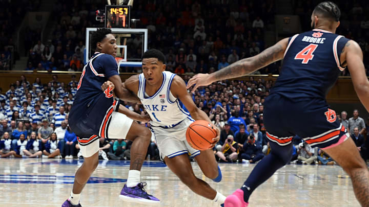 Dec 4, 2024; Durham, North Carolina, USA; Duke Blue Devils guard Caleb Foster (1) drives to the basket past Auburn Tigers guard Tahaad Pettiford (0) and center Johni Broome (4) during the second half at Cameron Indoor Stadium.  The Blue Devils won 84-78.   Mandatory Credit: Rob Kinnan-Imagn Images