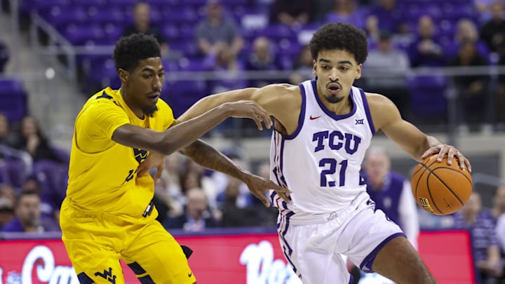 Feb 5, 2025; Fort Worth, Texas, USA; TCU Horned Frogs guard Noah Reynolds (21) drives to the basket as West Virginia Mountaineers guard Sencire Harris (10) defends during the first half at Ed and Rae Schollmaier Arena. Mandatory Credit: Kevin Jairaj-Imagn Images Feb 5, 2025; Fort Worth, Texas, USA; TCU Horned Frogs guard Noah Reynolds (21) drives to the basket as West Virginia Mountaineers guard Sencire Harris (10) defends during the first half at Ed and Rae Schollmaier Arena. Mandatory Credit: Kevin Jairaj-Imagn Images