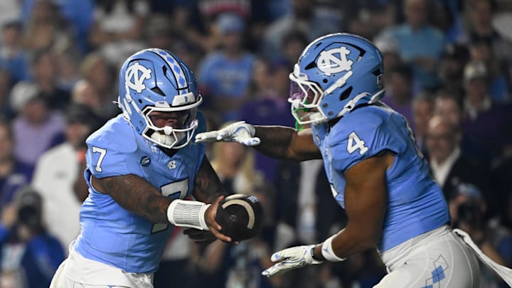 Sep 1, 2025; Chapel Hill, North Carolina, USA; North Carolina Tar Heels quarterback Gio Lopez (7) hands the ball off to running back Caleb Hood (4) in the first quarter at Kenan Stadium. Mandatory Credit: Bob Donnan-Imagn Images