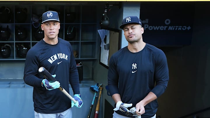 Jul 21, 2025; Toronto, Ontario, CAN; New York Yankees right fielder Aaron Judge (99) and  designated hitter Giancarlo Stanton (27) talk in the dugout during practice before a game against the Toronto Blue Jays at Rogers Centre. Mandatory Credit: Nick Turchiaro-Imagn Images