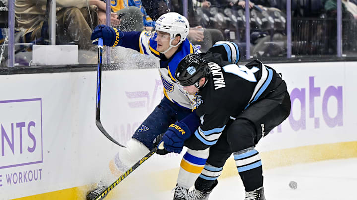 Jan 18, 2025; Salt Lake City, Utah, USA; St. Louis Blues right wing Alexey Toropchenko (13) battles with Utah Hockey Club defenseman Juuso Valimaki (4) for control of the puck during third period at the Delta Center. Mandatory Credit: Christopher Creveling-Imagn Images