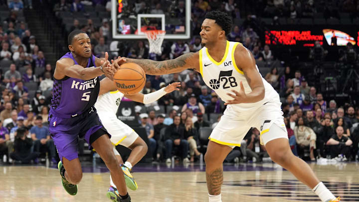 Dec 8, 2024; Sacramento, California, USA; Sacramento Kings guard De'Aaron Fox (5) and Utah Jazz forward Brice Sensabaugh (28) reach for a loose ball during the second quarter at Golden 1 Center. Mandatory Credit: Darren Yamashita-Imagn Images