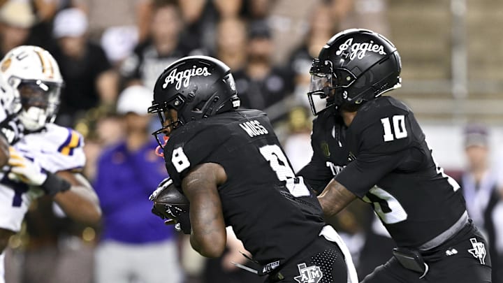 Oct 26, 2024; College Station, Texas, USA; Texas A&M Aggies quarterback Marcel Reed (10) hands off the ball to running back Le'Veon Moss (8) during the fourth quarter against the LSU Tigers. The Aggies defeated the Tigers 38-23; at Kyle Field. Mandatory Credit: Maria Lysaker-Imagn Images.  