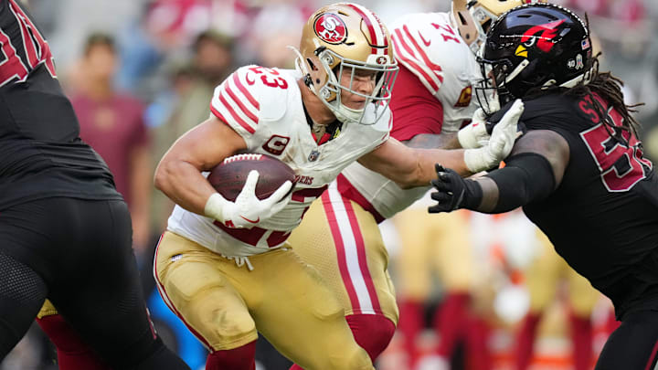 San Francisco 49ers Christian McCaffrey (23) stiff arms past Arizona Cardinals defensive lineman Dante Stills (55)at State Farm Stadium in Glendale on Nov. 16, 2025.