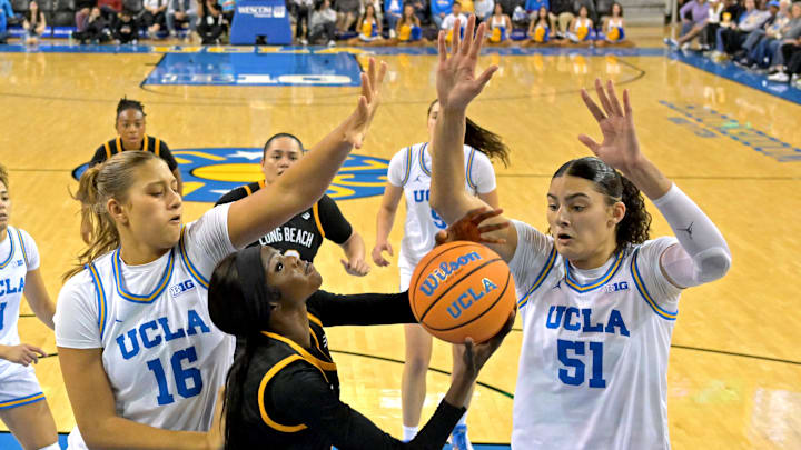 Dec 20, 2025; Los Angeles, California, USA; UCLA Bruins forward Sienna Betts (16) and center Lauren Betts (51) defend a shot by Long Beach State Beach forward Rosie Akot (2) during the second half at Pauley Pavilion presented by Wescom Financial. Mandatory Credit: Jayne Kamin-Oncea-Imagn Images