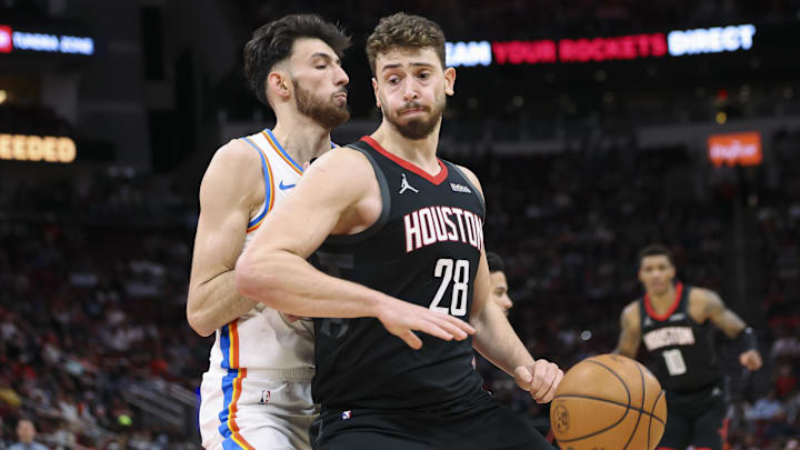 Jan 15, 2026; Houston, Texas, USA; Houston Rockets center Alperen Sengun (28) attempts to dribble the ball around Oklahoma City Thunder center Chet Holmgren (7) during the second quarter at Toyota Center. Mandatory Credit: Troy Taormina-Imagn Images