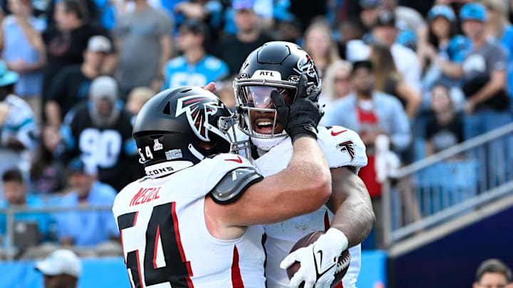 Oct 13, 2024; Charlotte, North Carolina, USA; Atlanta Falcons running back Bijan Robinson (7) celebrates with guard Ryan Neuzil (64) after scoring a touchdown in the first quarter at Bank of America Stadium. Mandatory Credit: Bob Donnan-Imagn Images