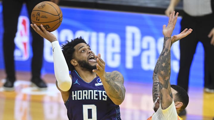 Dec 22, 2025; Cleveland, Ohio, USA; Charlotte Hornets forward Miles Bridges (0) shoots beside Cleveland Cavaliers guard Lonzo Ball (2) in the fourth quarter at Rocket Arena. Mandatory Credit: David Richard-Imagn Images