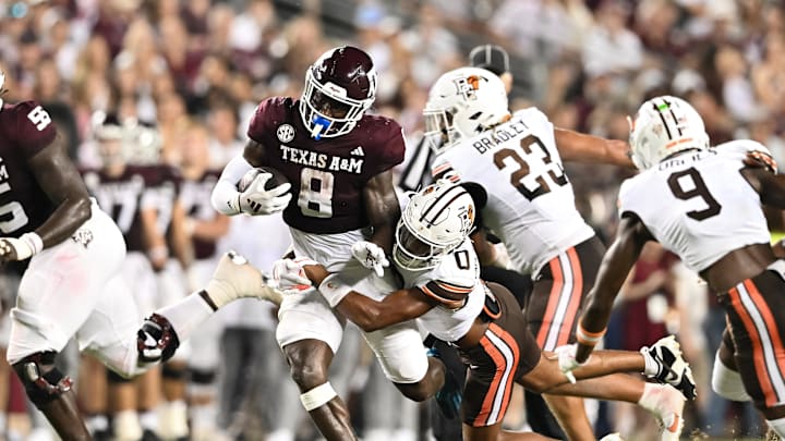 Sep 21, 2024; College Station, Texas, USA; Texas A&M Aggies running back Le'Veon Moss (8) is tackled by Bowling Green Falcons cornerback Darius McClendon (0) during the first half at Kyle Field. Mandatory Credit: Maria Lysaker-Imagn Images. 