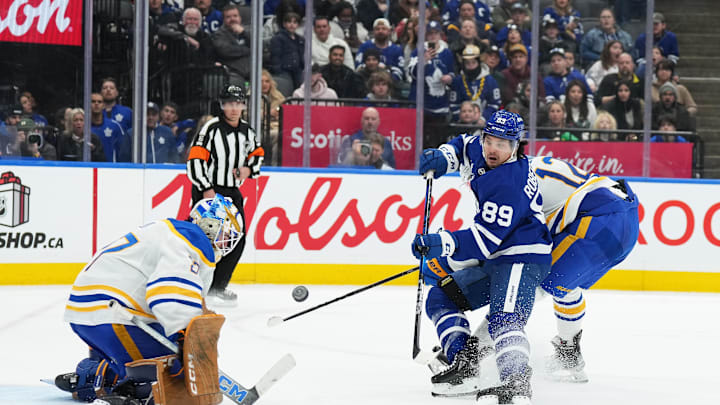 Dec 15, 2024; Toronto, Ontario, CAN; Toronto Maple Leafs left wing Nicholas Robertson (89) battles for the puck in front of the net with Buffalo Sabres left wing Jordan Greenway (12) during the third period at Scotiabank Arena. Mandatory Credit: Nick Turchiaro-Imagn Images