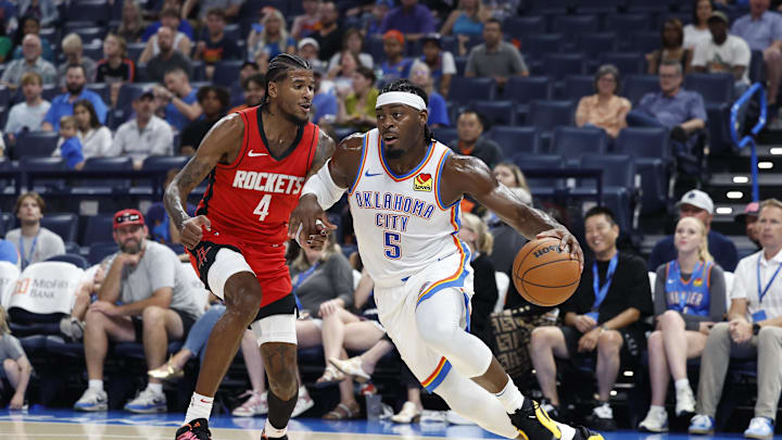 Oct 9, 2024; Oklahoma City, Oklahoma, USA; Oklahoma City Thunder guard Luguentz Dort (5) drives to the basket around Houston Rockets guard Jalen Green (4) during the first quarter at Paycom Center. Mandatory Credit: Alonzo Adams-Imagn Images