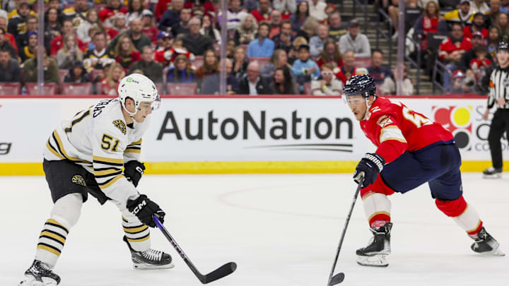 Nov 22, 2023; Sunrise, Florida, USA; Boston Bruins center Matthew Poitras (51) moves the puck against Florida Panthers defenseman Brandon Montour (62) during the first period at Amerant Bank Arena. Mandatory Credit: Sam Navarro-Imagn Images