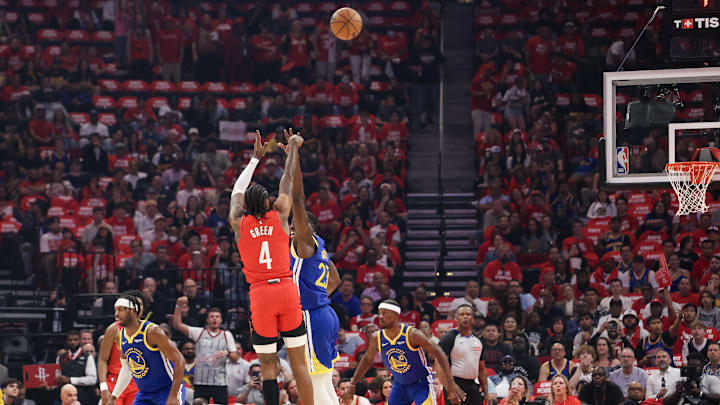 Apr 30, 2025; Houston, Texas, USA; Houston Rockets guard Jalen Green (4) makes a three point basket against Golden State Warriors forward Draymond Green (23) in the first quarter during game five of first round for the 2025 NBA Playoffs at Toyota Center. Mandatory Credit: Thomas Shea-Imagn Images