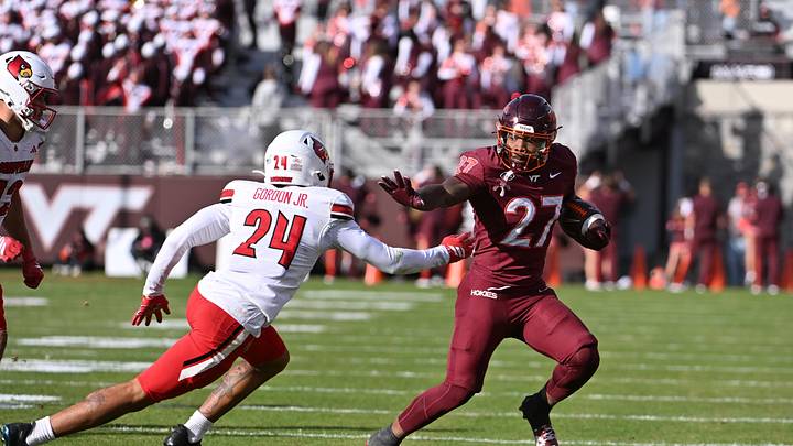 Nov 1, 2025; Blacksburg, Virginia, USA; Virginia Tech Hokies running back Marcellous Hawkins (27) runs the ball as Louisville Cardinals defensive back Corey Gordon (24) defends during the second quarter at Lane Stadium. Mandatory Credit: Brian Bishop-Imagn Images Nov 1, 2025; Blacksburg, Virginia, USA; Virginia Tech Hokies running back Marcellous Hawkins (27) runs the ball as Louisville Cardinals defensive back Corey Gordon (24) defends during the second quarter at Lane Stadium. Mandatory Credit: Brian Bishop-Imagn Images