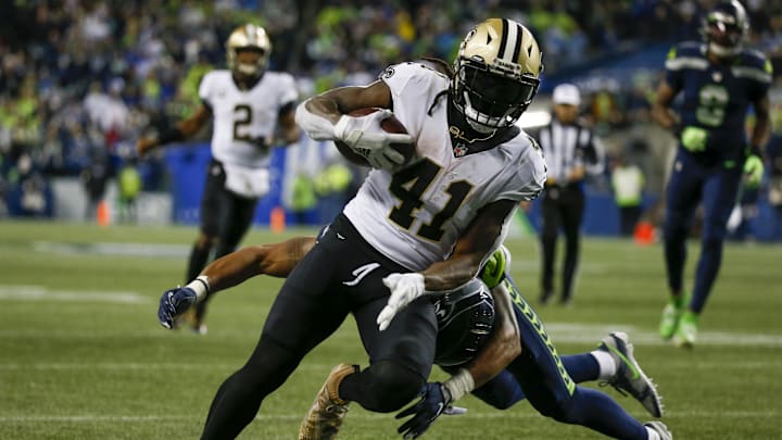 Oct 25, 2021; Seattle, Washington, USA; New Orleans Saints running back Alvin Kamara (41) breaks a tackle by Seattle Seahawks defensive back Ryan Neal (26) to score a touchdown on a reception during the second quarter at Lumen Field. Mandatory Credit: Joe Nicholson-Imagn Images