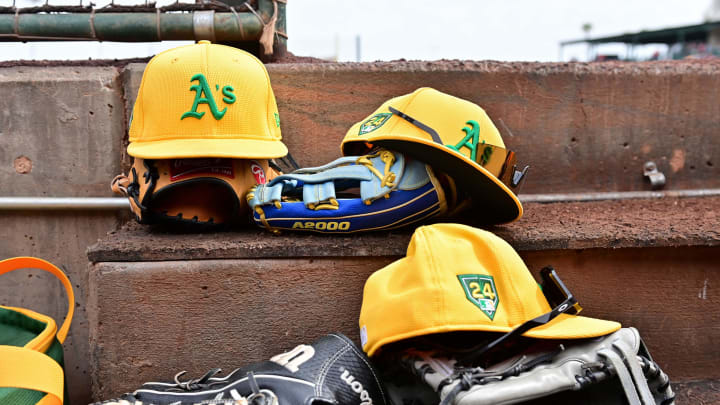 Mar 6, 2024; Tempe, Arizona, USA; General view of Oakland Athletics hats and gloves prior to a spring training game against the Los Angeles Angels at Tempe Diablo Stadium. Mandatory Credit: Matt Kartozian-USA TODAY Sports Mar 6, 2024; Tempe, Arizona, USA; General view of Oakland Athletics hats and gloves prior to a spring training game against the Los Angeles Angels at Tempe Diablo Stadium. Mandatory Credit: Matt Kartozian-USA TODAY Sports