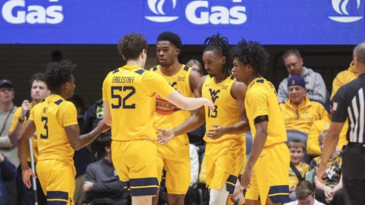 Jan 10, 2026; Morgantown, West Virginia, USA; West Virginia Mountaineers guard Chance Moore (13) celebrates with teammates after a play during the first half against the Kansas Jayhawks at Hope Coliseum. Mandatory Credit: Ben Queen-Imagn Images