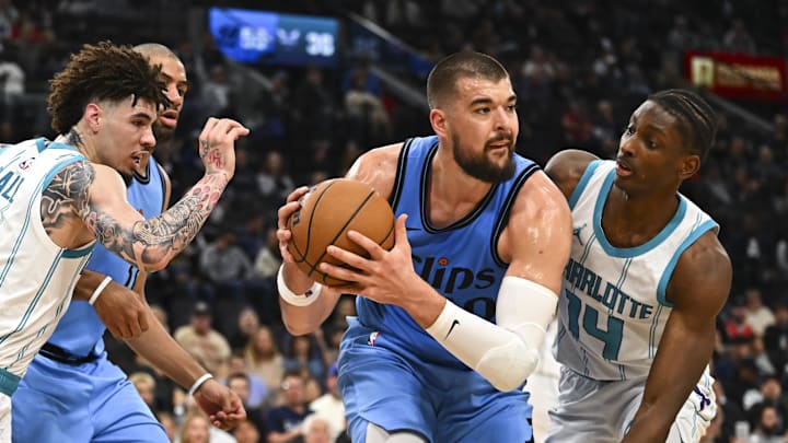 Mar 16, 2025; Inglewood, California, USA; LA Clippers center Ivica Zubac (40) looks to pass against Charlotte Hornets guard LaMelo Ball (1) and forward Moussa Diabate (14) during the first half at Intuit Dome. Mandatory Credit: Jonathan Hui-Imagn Images