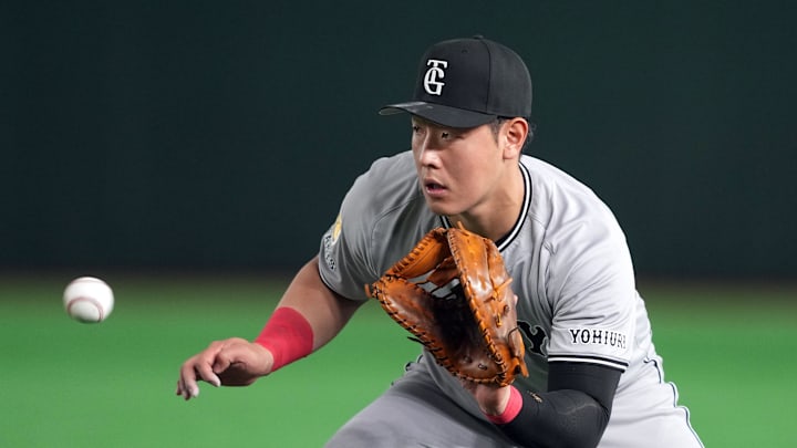 Mar 15, 2025; Bunkyo, Tokyo, Japan; Yomiuri Giants first baseman Kazuma Okamoto (25) fields a ground ball against the Los Angeles Dodgers during the fifth inning at Tokyo Dome. Mandatory Credit: Darren Yamashita-Imagn Images