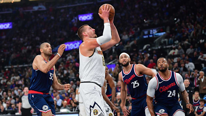 Apr 24, 2025; Inglewood, California, USA; Denver Nuggets center Nikola Jokic (15) moves to the basket against Los Angeles Clippers forward Nicolas Batum (33) guard Ben Simmons (25) and guard Norman Powell (24) during the first half of game three in the first round for the 2024 NBA Playoffs at Intuit Dome. Mandatory Credit: Gary A. Vasquez-Imagn Images