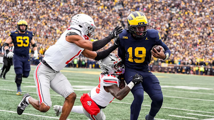 Michigan quarterback Bryce Underwood (19) runs against Ohio State safety Jaylen McClain (18) and cornerback Davison Igbinosun (1) during the first half at Michigan Stadium in Ann Arbor on Saturday, Nov. 29, 2025.