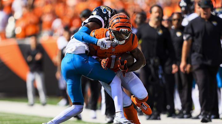 Sep 14, 2025; Cincinnati, Ohio, USA; Cincinnati Bengals wide receiver Ja'Marr Chase (1) runs with the ball against Jacksonville Jaguars defensive back Travis Hunter (12) in the second half at Paycor Stadium. Mandatory Credit: Katie Stratman-Imagn Images