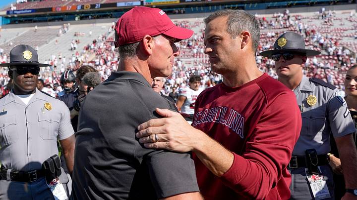 Oklahoma coach Brent Venables talks with South Carolina coach Shane Beamer after a college football game between the University of Oklahoma Sooners (OU) and the South Carolina Gamecocks.