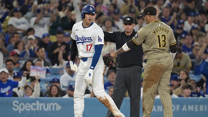 Sep 26, 2024; Los Angeles, California, USA;  Los Angeles Dodgers designated hitter Shohei Ohtani (17) and San Diego Padres third baseman Manny Machado (13) talk on the base during the seventh inning at Dodger Stadium. Mandatory Credit: Jayne Kamin-Oncea-Imagn Images