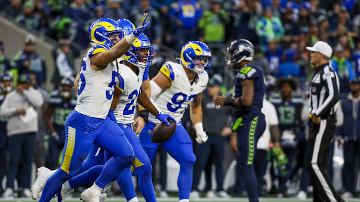 Nov 3, 2024; Seattle, Washington, USA; Los Angeles Rams safety Kamren Kinchens (26) celebrates following an interception against Seattle Seahawks quarterback Geno Smith (7, background second from right) during the fourth quarter at Lumen Field. Mandatory Credit: Joe Nicholson-Imagn Images