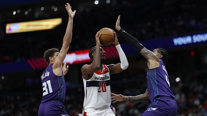 Dec 19, 2024; Washington, District of Columbia, USA; Washington Wizards forward Alexandre Sarr (20) shoots the ball as Charlotte Hornets forward Tidjane Salaun (31) and Hornets center Nick Richards (4) defend in the third quarter at Capital One Arena. Mandatory Credit: Geoff Burke-Imagn Images