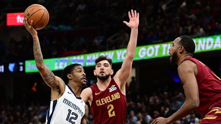 Feb 23, 2025; Cleveland, Ohio, USA; Memphis Grizzlies guard Ja Morant (12) drives to the basket against Cleveland Cavaliers guard Ty Jerome (2) and forward Evan Mobley (4) during the second half at Rocket Arena. Mandatory Credit: Ken Blaze-Imagn Images