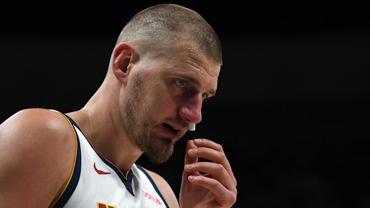 Apr 18, 2026; Denver, Colorado, USA; Denver Nuggets center Nikola Jokic (15) tends to a bloody nose during the first quarter against the Minnesota Timberwolvesin game one of the first round of the 2026 NBA Playoffs at Ball Arena. Mandatory Credit: Christopher Hanewinckel-Imagn Images