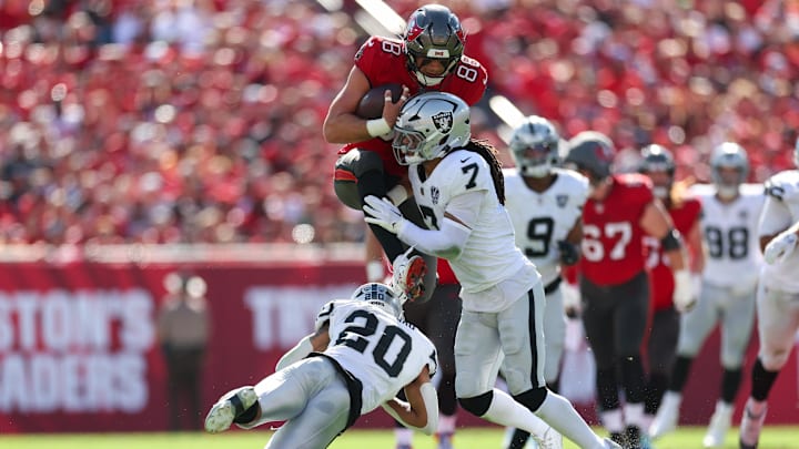 Dec 8, 2024; Tampa, Florida, USA; Tampa Bay Buccaneers tight end Cade Otton (88) is stopped by Las Vegas Raiders safety Tre'von Moehrig (7) in the first quarter at Raymond James Stadium. Mandatory Credit: Nathan Ray Seebeck-Imagn Images