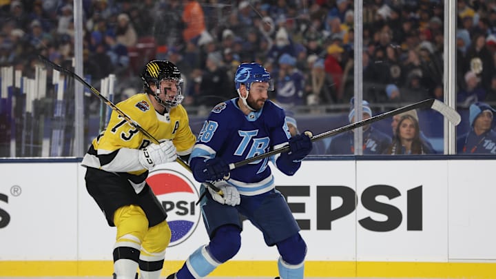 Feb 1, 2026; Tampa Bay, Florida, USA; Boston Bruins defenseman Charlie McAvoy (73) and Tampa Bay Lightning center Zemgus Girgensons (28) chase down the puck during the second period in the 2026 Stadium Series ice hockey game at Raymond James Stadium. Mandatory Credit: Kim Klement Neitzel-Imagn Images