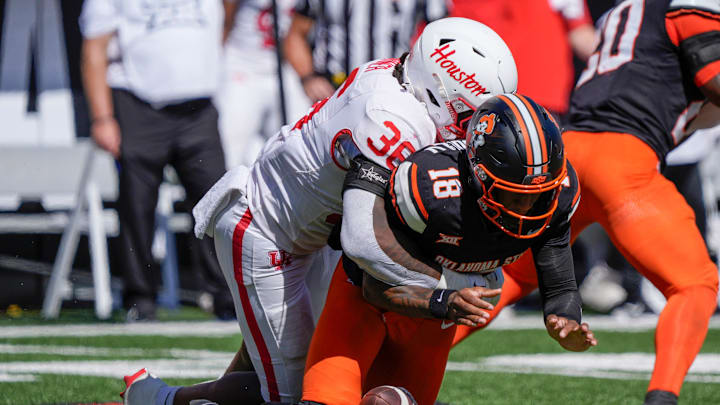 Oklahoma State Cowboys quarterback Sam Jackson V (18) fumbles the ball as he is hit by Houston Cougars linebacker Jalen Garner (36) during a college football game between the Oklahoma State Cowboys (OSU) and the Houston Cougars at Boone Pickens Stadium in Stillwater, Okla., Saturday, Oct. 11, 2025. Houston won 39-17. Oklahoma State Cowboys quarterback Sam Jackson V (18) fumbles the ball as he is hit by Houston Cougars linebacker Jalen Garner (36) during a college football game between the Oklahoma State Cowboys (OSU) and the Houston Cougars at Boone Pickens Stadium in Stillwater, Okla., Saturday, Oct. 11, 2025. Houston won 39-17.