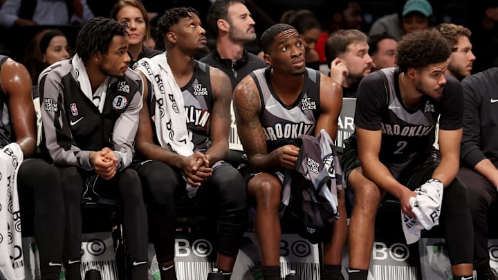 Dec 16, 2024; Brooklyn, New York, USA; Brooklyn Nets center Nic Claxton (33) and forward Dorian Finney-Smith (28) and guard Shake Milton (7) and forward Cameron Johnson (2) watch from the bench during the fourth quarter against the Cleveland Cavaliers at Barclays Center. Mandatory Credit: Brad Penner-Imagn Images