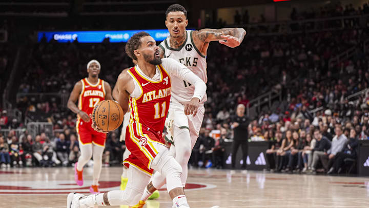 Mar 4, 2025; Atlanta, Georgia, USA; Atlanta Hawks guard Trae Young (11) tries to take the ball past Milwaukee Bucks forward Kyle Kuzma (18) during the second half at State Farm Arena. Mandatory Credit: Dale Zanine-Imagn Images