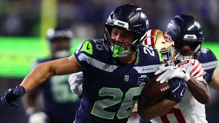 Jan 17, 2026; Seattle, WA, USA; Seattle Seahawks running back Zach Charbonnet (26) carries the ball as San Francisco 49ers cornerback Renardo Green (0) defends during the first half in an NFC Divisional Round game at Lumen Field. Mandatory Credit: Kevin Ng-Imagn Images