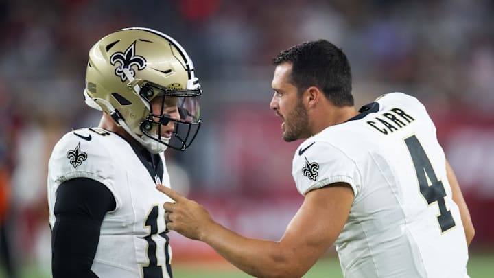 Aug 10, 2024; Glendale, Arizona, USA; New Orleans Saints quarterback Derek Carr (4) talks with Spencer Rattler (18) against the Arizona Cardinals during a preseason NFL game at State Farm Stadium. Mandatory Credit: Mark J. Rebilas-Imagn Images Aug 10, 2024; Glendale, Arizona, USA; New Orleans Saints quarterback Derek Carr (4) talks with Spencer Rattler (18) against the Arizona Cardinals during a preseason NFL game at State Farm Stadium. Mandatory Credit: Mark J. Rebilas-Imagn Images
