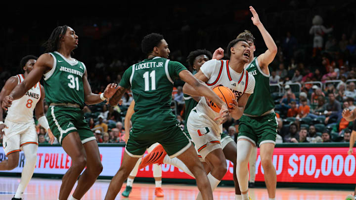 Nov 3, 2025; Coral Gables, Florida, USA; Miami Hurricanes forward Malik Reneau (5) drives to the basket against Jacksonville Dolphins guard Chris Lockett (11) during the first half at Watsco Center. Mandatory Credit: Sam Navarro-Imagn Images Nov 3, 2025; Coral Gables, Florida, USA; Miami Hurricanes forward Malik Reneau (5) drives to the basket against Jacksonville Dolphins guard Chris Lockett (11) during the first half at Watsco Center. Mandatory Credit: Sam Navarro-Imagn Images