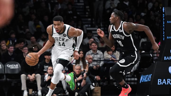 Dec 8, 2024; Brooklyn, New York, USA; Milwaukee Bucks forward Giannis Antetokounmpo (34) brings the ball up court while being defended by Brooklyn Nets forward Dorian Finney-Smith (28) during the second half at Barclays Center. Mandatory Credit: John Jones-Imagn Images
