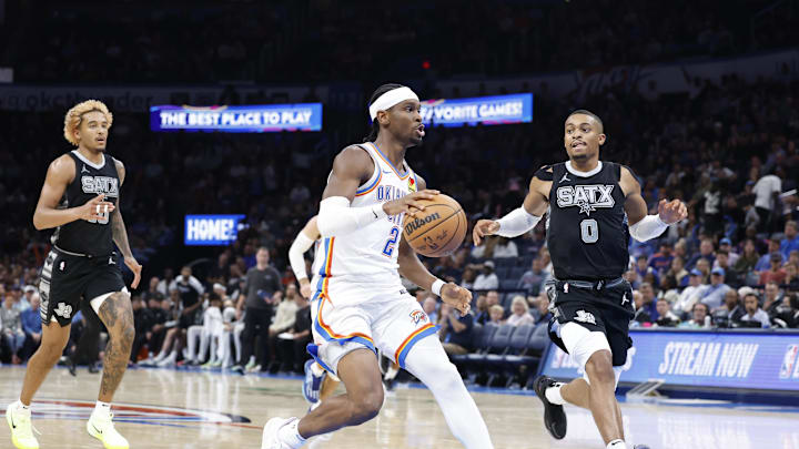 Oct 30, 2024; Oklahoma City, Oklahoma, USA; Oklahoma City Thunder guard Shai Gilgeous-Alexander (2) drives to the basket beside San Antonio Spurs forward Keldon Johnson (0) during the second half at Paycom Center. Mandatory Credit: Alonzo Adams-Imagn Images