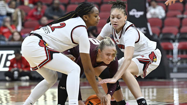 Dec 17, 2025; Louisville, Kentucky, USA;  Louisville Cardinals guard Tajianna Roberts (22) and guard Imari Berry (2) trap Eastern Kentucky Colonels guard Kenleigh Woods (10) during the first half at KFC Yum! Center. Mandatory Credit: Jamie Rhodes-Imagn Images
