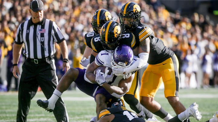Iowa’s Nick Jackson (10), Deshaun Lee (8), Xavier Nwankpa (1), and Quinn Schulte (30) tackle Northwestern’s Cam Porter (1) Saturday, Oct. 26, 2024 at Kinnick Stadium in Iowa City, Iowa.