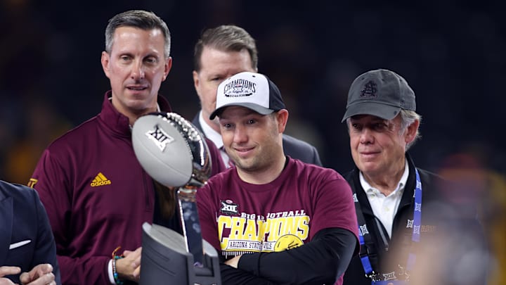 Dec 7, 2024; Arlington, TX, USA; Arizona State Sun Devils head coach Kenny Dillingham looks at the trophy after winning the Big 12 Championship game against the Iowa State Cyclones at AT&T Stadium. Mandatory Credit: Tim Heitman-Imagn Images Dec 7, 2024; Arlington, TX, USA; Arizona State Sun Devils head coach Kenny Dillingham looks at the trophy after winning the Big 12 Championship game against the Iowa State Cyclones at AT&T Stadium. Mandatory Credit: Tim Heitman-Imagn Images