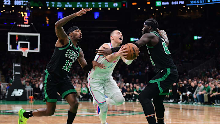 Apr 2, 2025; Boston, Massachusetts, USA; Miami Heat guard Tyler Herro (14) controls the ball between Boston Celtics forward Torrey Craig (12) and center Neemias Queta (88) during the first half at TD Garden. Mandatory Credit: Bob DeChiara-Imagn Images