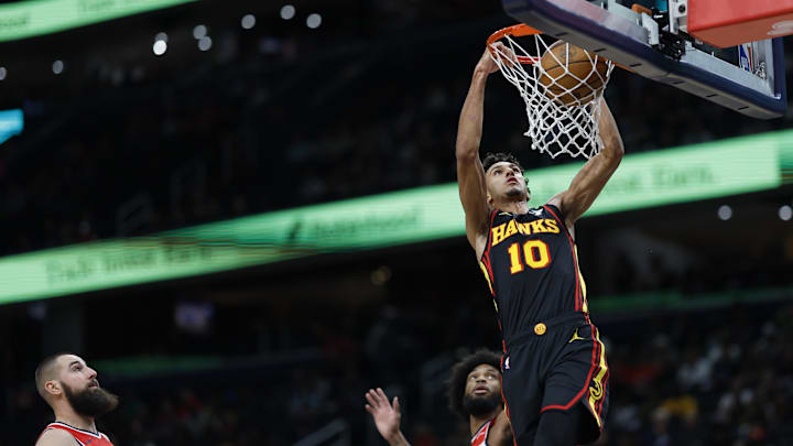 Oct 30, 2024; Washington, District of Columbia, USA; Atlanta Hawks forward Zaccharie Risacher (10) dunks the ball as Washington Wizards center Jonas Valanciunas (17) and Wizards forward Marvin Bagley III (35) look on in the first half at Capital One Arena. Mandatory Credit: Geoff Burke-Imagn Images